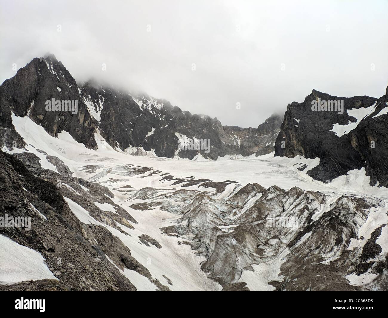 ghiacciaio bianco coperto montagna nera Foto Stock