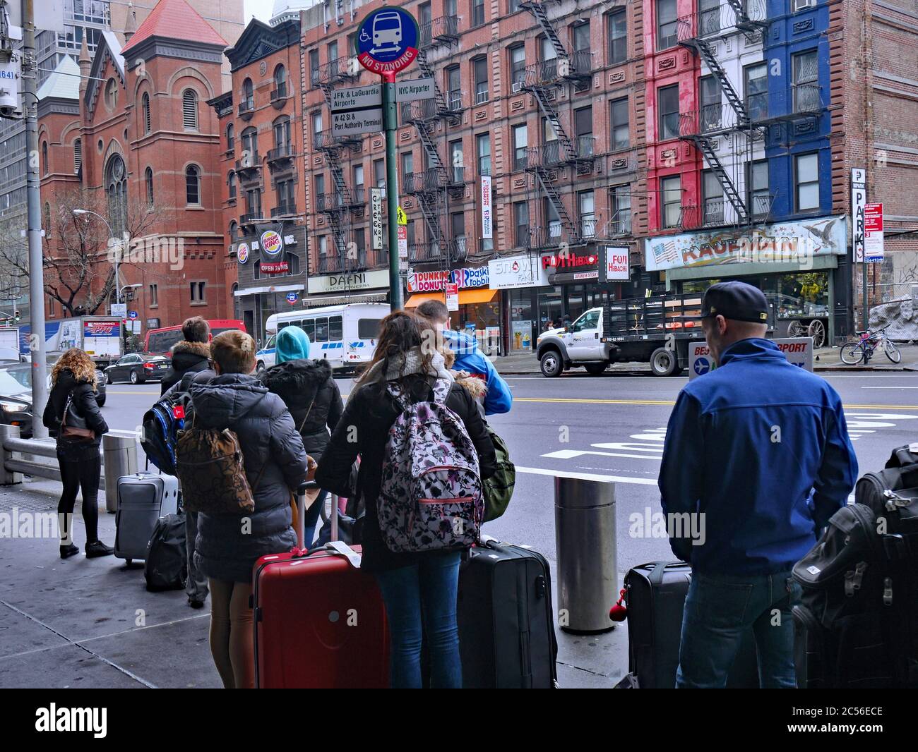 New York, NY - 27 marzo 2017: I viaggiatori che arrivano al terminal degli autobus della Port Authority aspettano sul marciapiede esterno per i taxi e gli autobus della città. Foto Stock