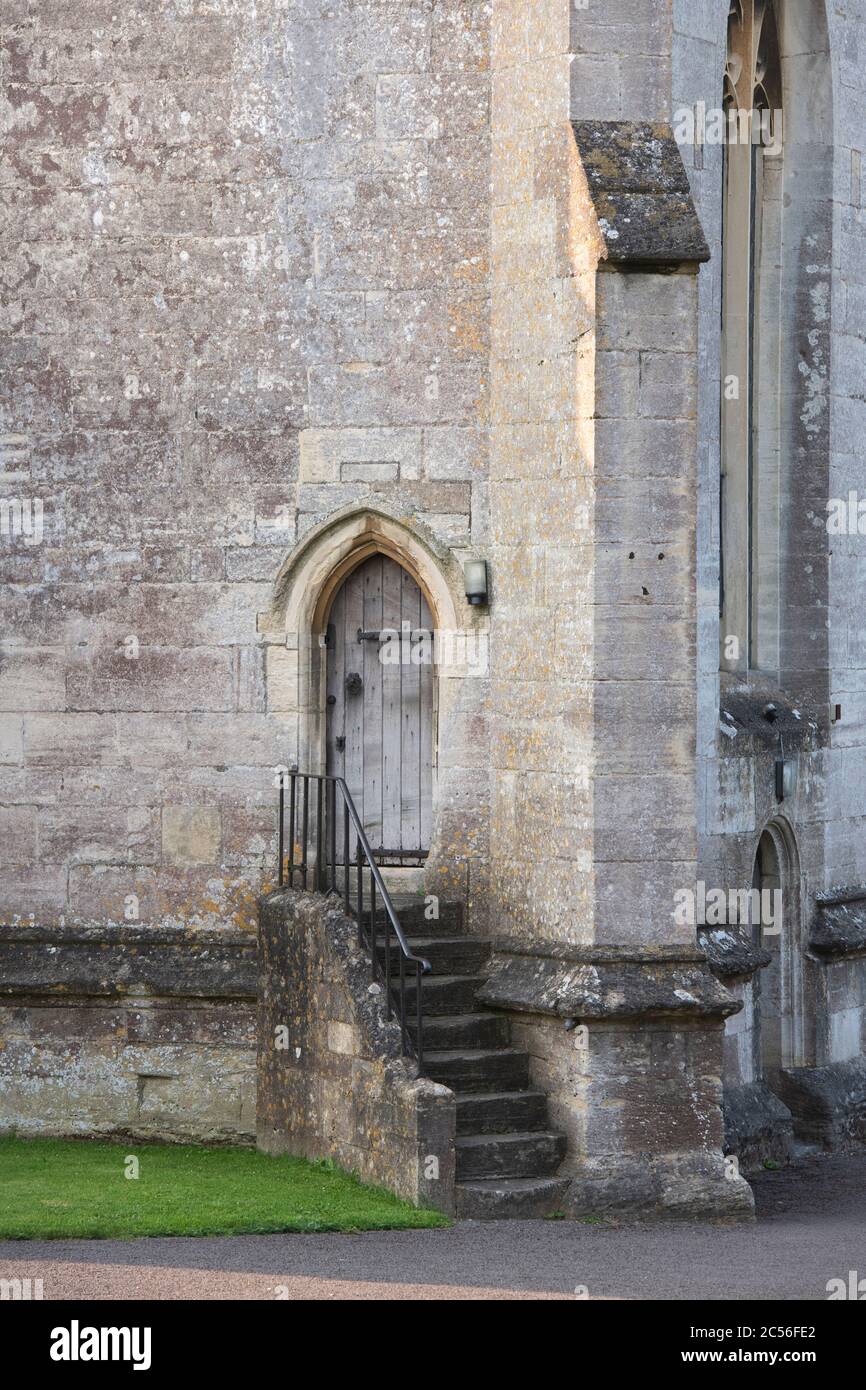 Piccola porta laterale della chiesa e scalini in pietra nella chiesa di St Marys. Painswick, Gloucestershire, Inghilterra Foto Stock