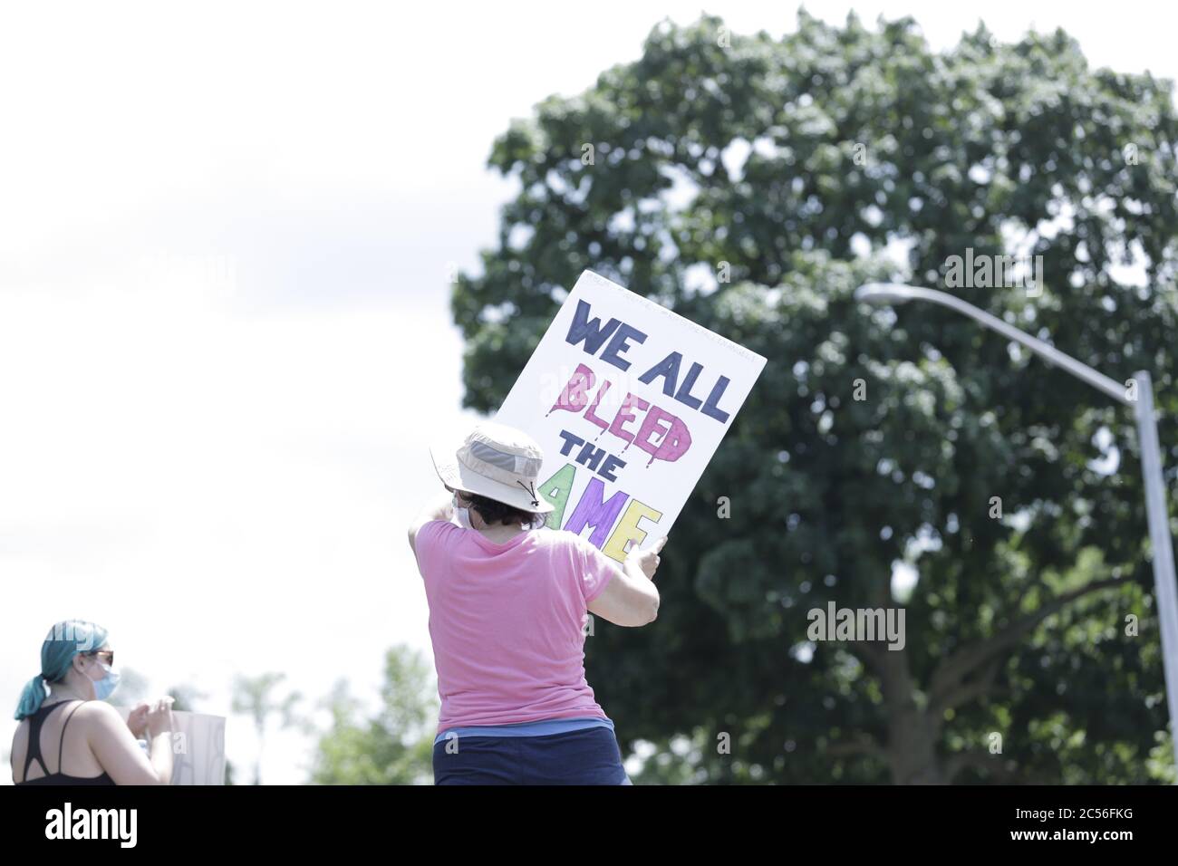 Una donna non identificata tiene un poster a sostegno della protesta contro il razzismo e la questione Black Lives ad Hamilton, Ontario Canada Foto Stock