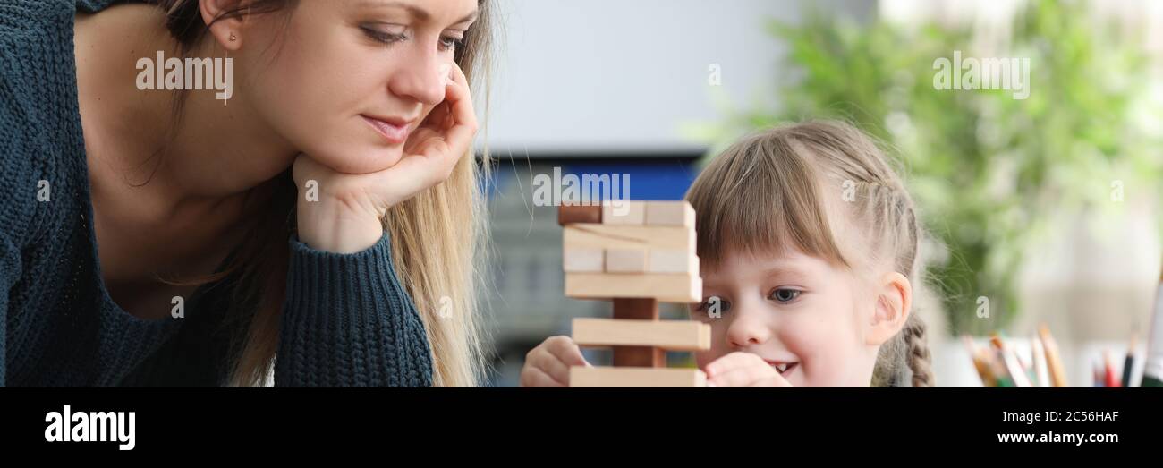 Mamma aiuta pazientemente la sua figlia a costruire la struttura Foto Stock