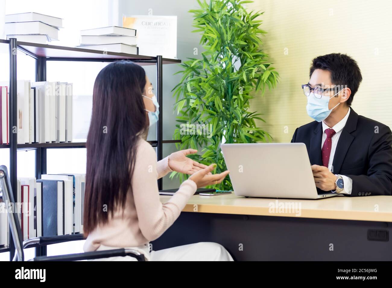 Ritratto di consulente asiatico di affari che dà consiglio al cliente circa la situazione di prestito finanziario in ufficio bancario. Nuovo business a distanza sociale normale per ba Foto Stock