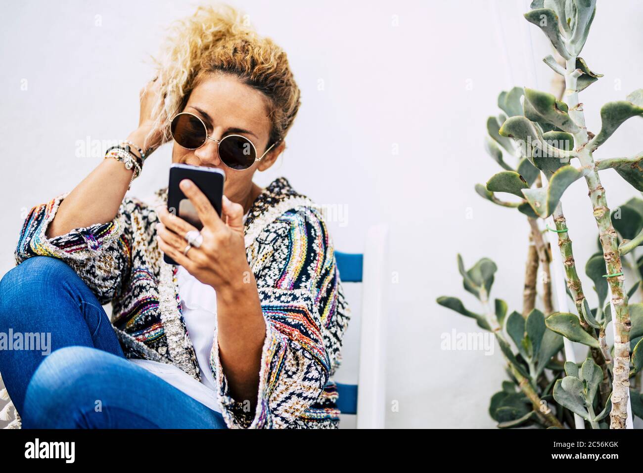 Felice moda trendy giovane bella donna utilizzare il telefono moderno tecnologia per chiamare gli amici - persone e dispositivi internet all'aperto - sfondo bianco e gr Foto Stock