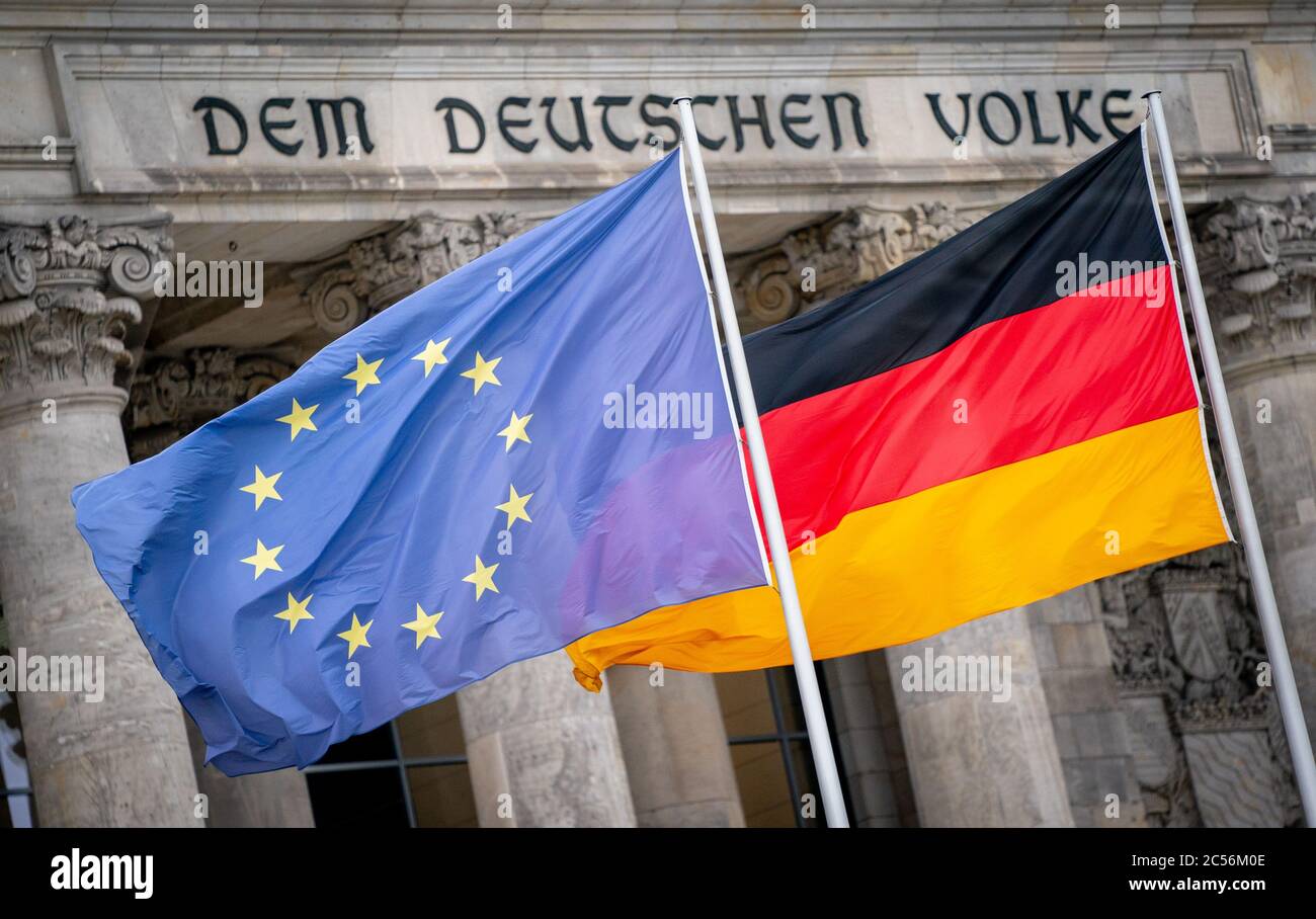 Berlino, Germania. 01 Luglio 2020. La bandiera tedesca ed europea sventolano al vento la mattina davanti all'edificio del Reichstag. La Germania assume la presidenza del Consiglio dell'Unione europea per sei mesi a partire dal 1° luglio 2020. Il tema principale della Presidenza dell'Unione europea sarà il superamento della pandemia di Corona e delle sue gravi conseguenze economiche. Credit: Kay Nietfeld/dpa/Alamy Live News Foto Stock