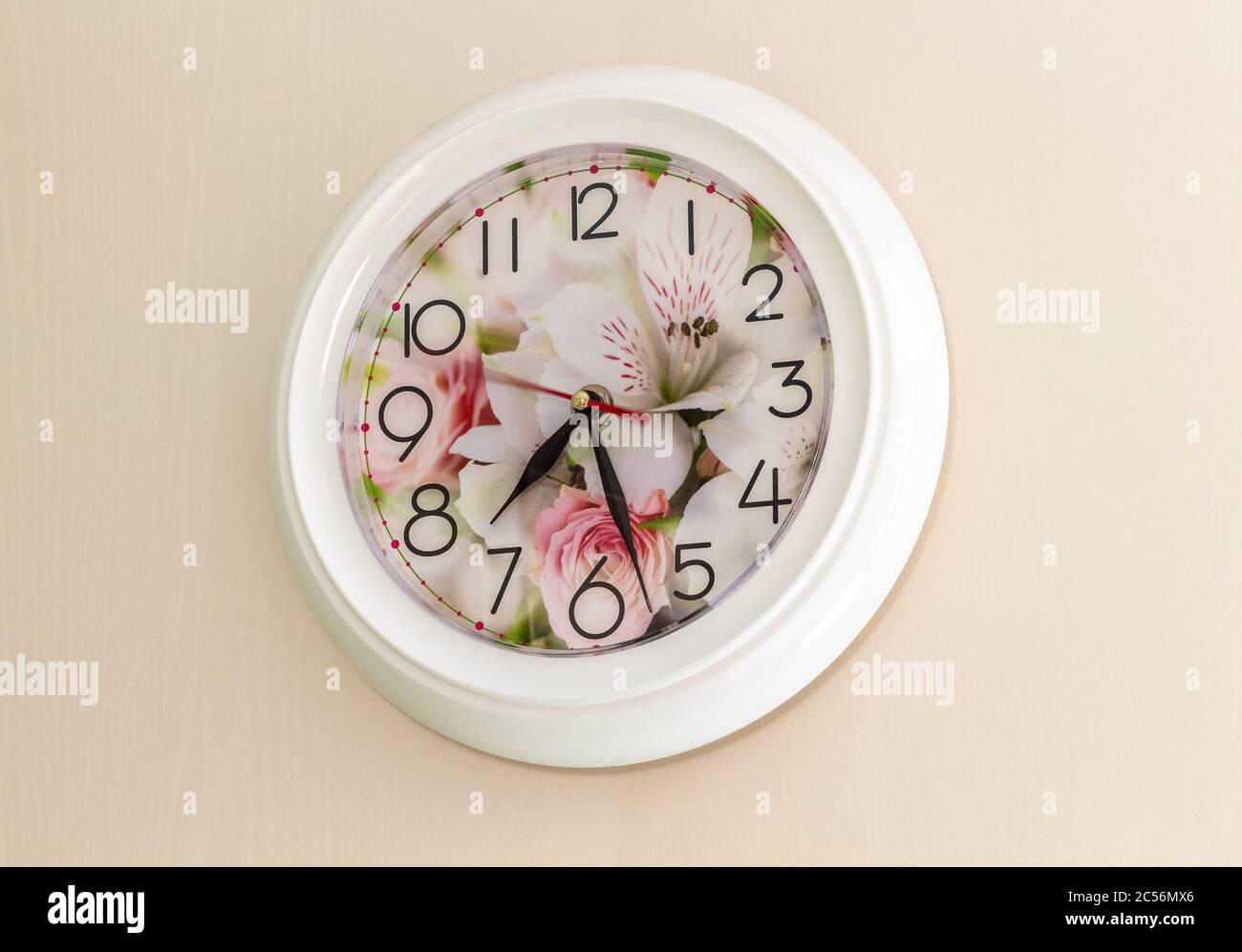Orologio rotondo bianco su una parete beige. Foto Stock