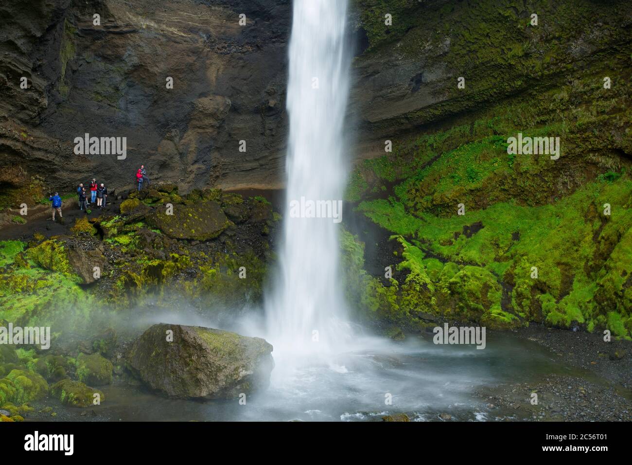 I turisti si meravigliano del Kvernufoss, alto 40 m, vicino a Skogar, nell'Islanda meridionale. Foto Stock