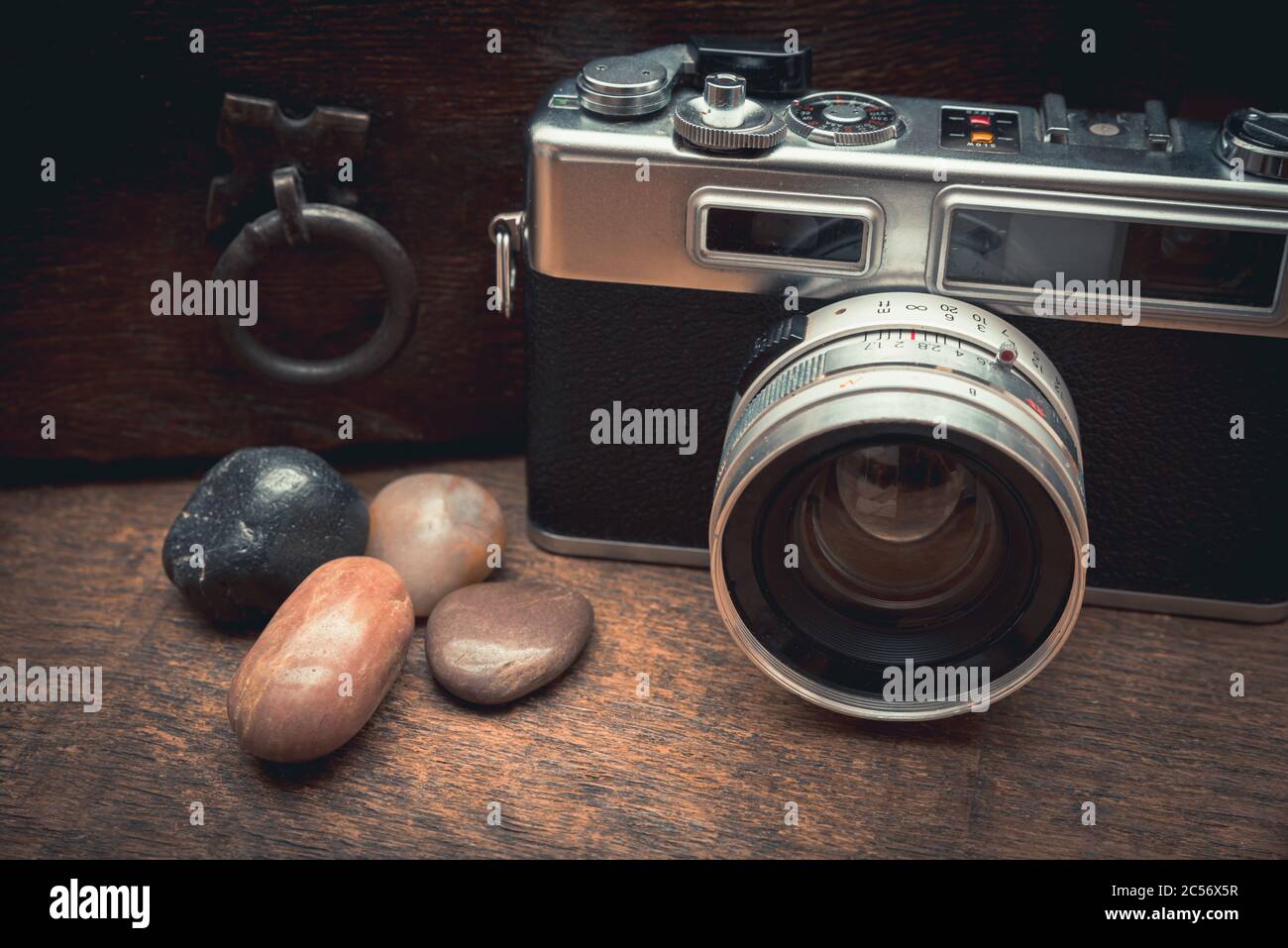 Macchina fotografica d'epoca e pietre naturali su un tavolo di legno vicino il vecchio petto Foto Stock