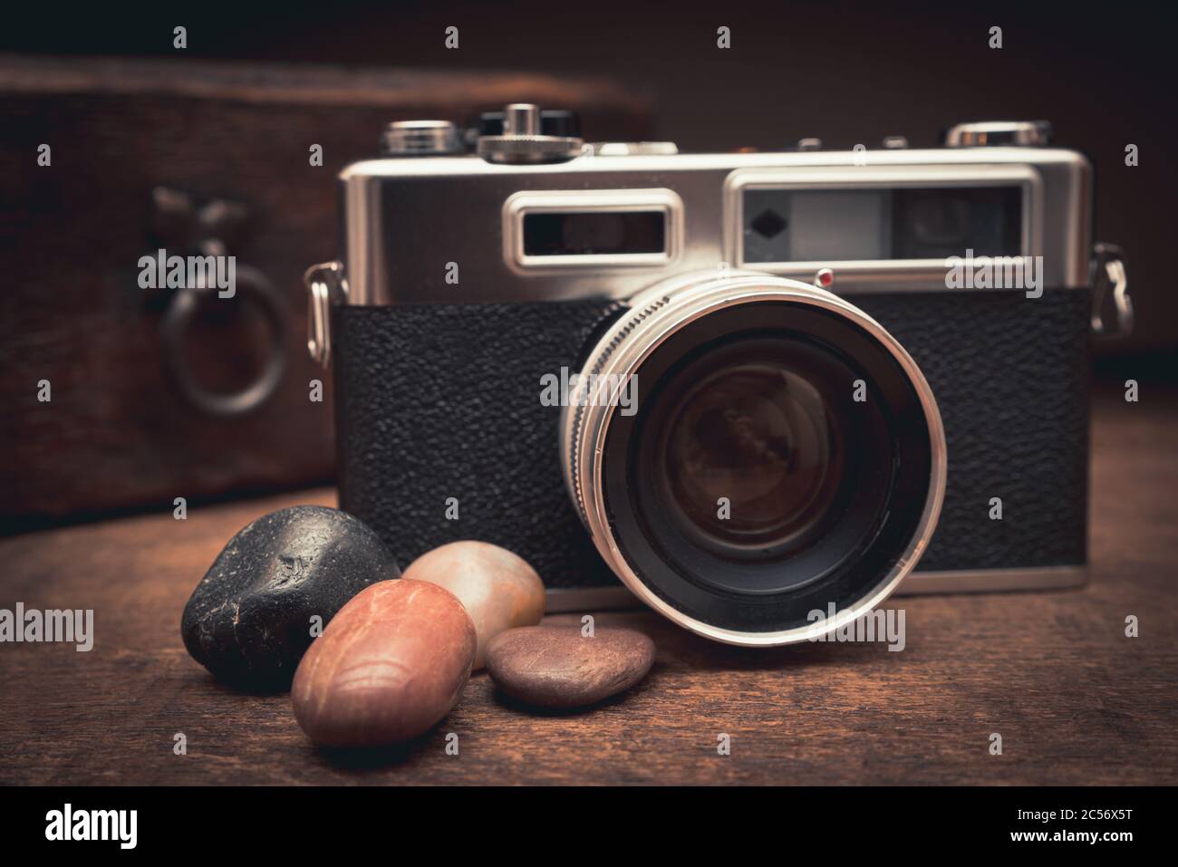 Macchina fotografica d'epoca e pietre naturali su un tavolo di legno vicino il vecchio petto Foto Stock