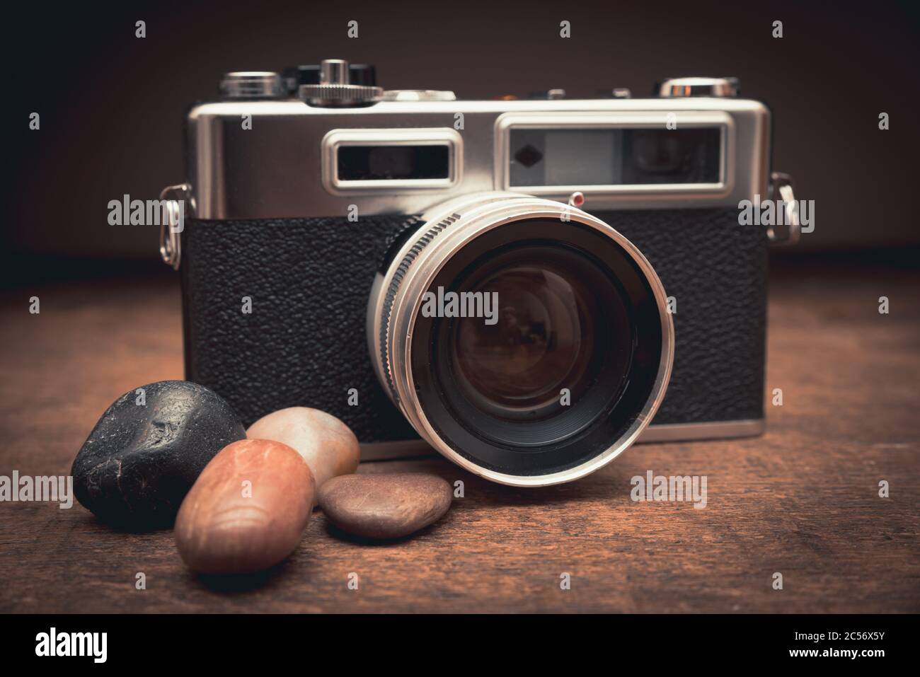 Vecchia macchina fotografica d'epoca con pietre naturali su un tavolo di legno Foto Stock
