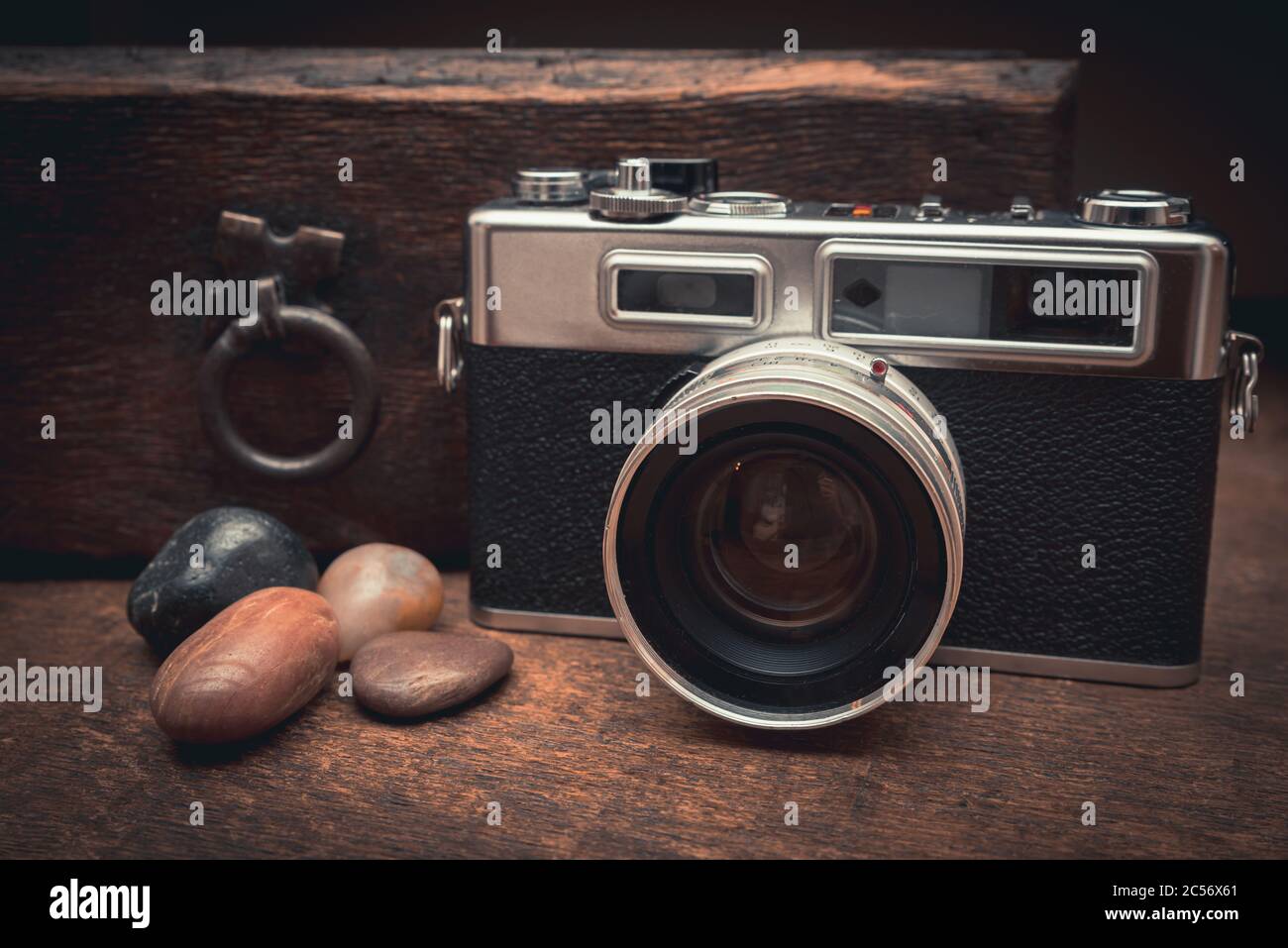 Macchina fotografica d'epoca e pietre naturali su un tavolo di legno vicino il vecchio petto Foto Stock