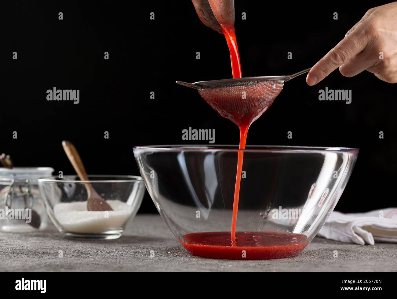 Sciroppo di succhiatura preparazione della confettura di fragole versando sciroppo di fragole, primo piano Foto Stock