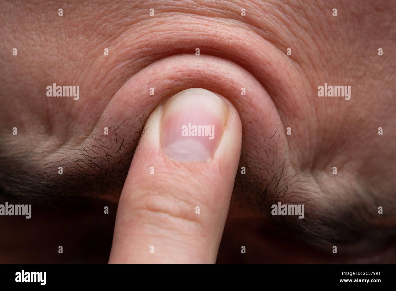 Foto della fronte dell'uomo con il dito, primo piano Foto Stock