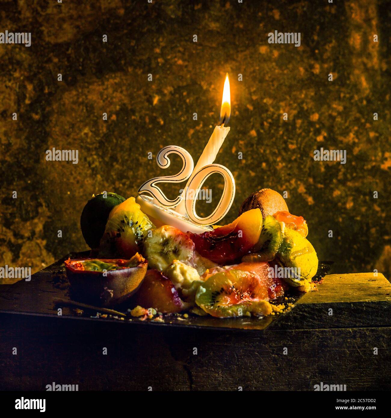 Dessert con frutta e candela per il ventesimo compleanno Foto Stock