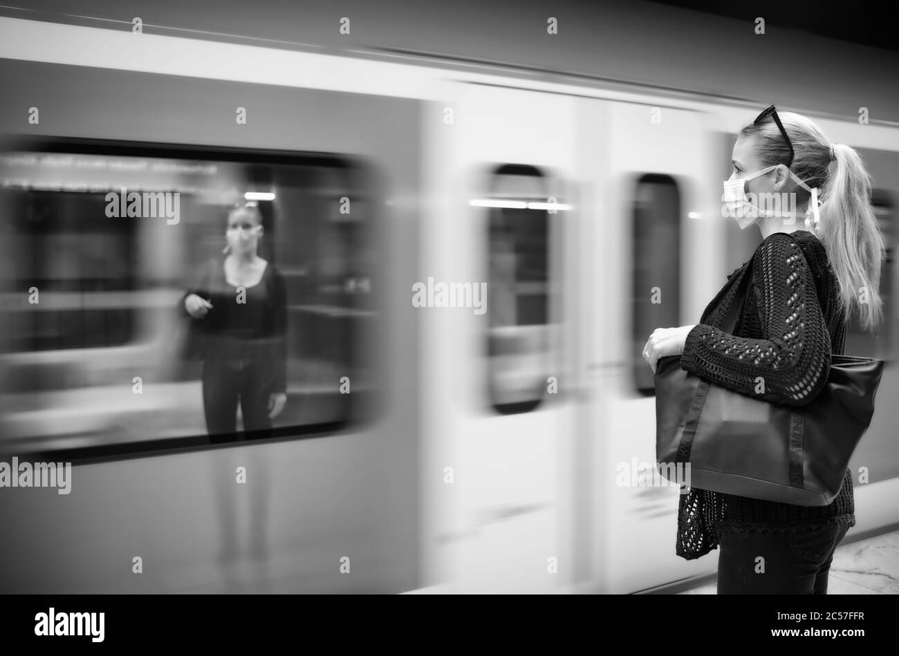 Donna con maschera facciale, in attesa di treno, riflessa in S-Bahn, crisi di Corona, Stoccarda, Baden-Württemberg, Germania Foto Stock
