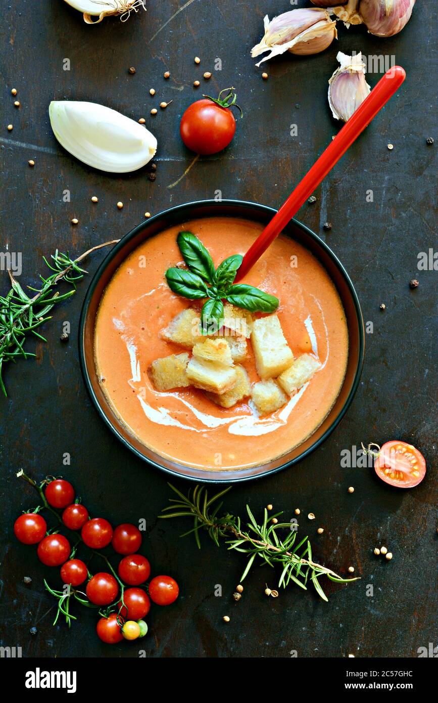 Zuppa di pomodoro Gazpacho fresca con cracker (crostini), erbe fresche,  aglio su fondo scuro. Zuppa fredda estiva leggera, cucina spagnola. Cibo  vegano, lui Foto stock - Alamy