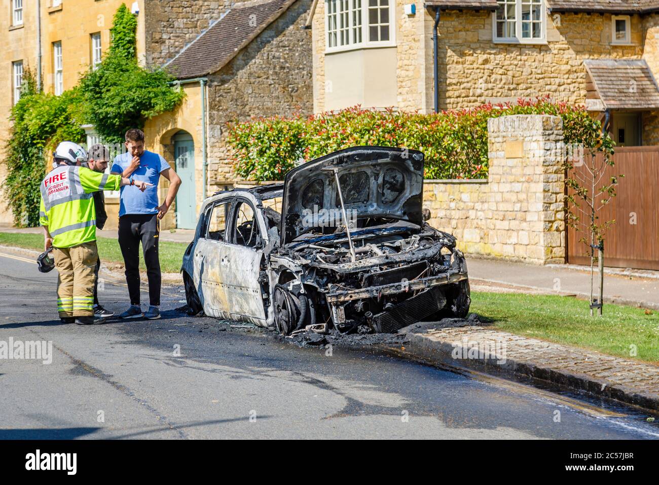 Un'auto completamente bruciata sul lato della strada in High Street, Chipping Campden, una piccola città di mercato nel Cotswolds in Gloucestershire Foto Stock