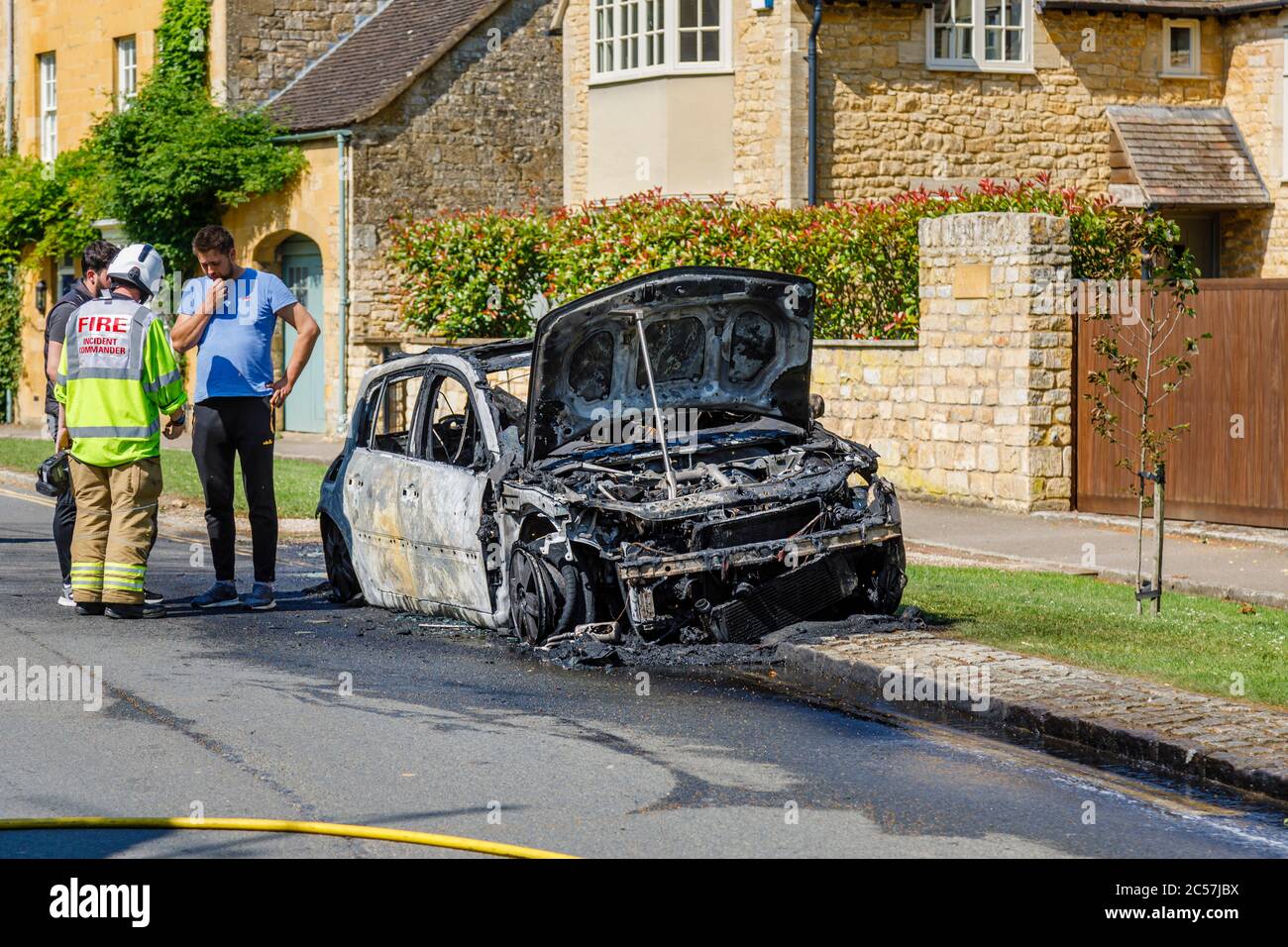 Un'auto completamente bruciata sul lato della strada in High Street, Chipping Campden, una piccola città di mercato nel Cotswolds in Gloucestershire Foto Stock