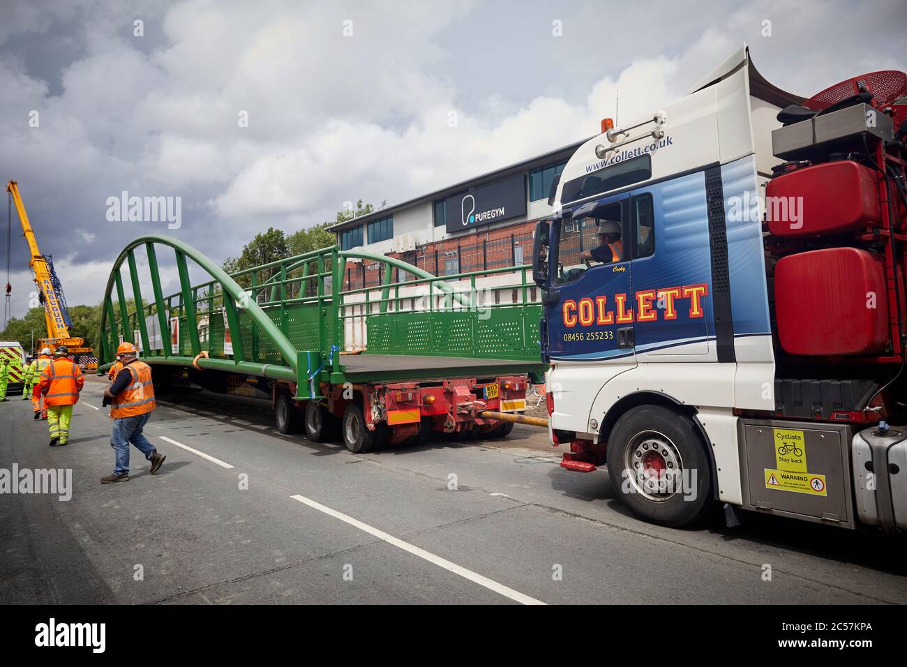 A57 Hyde Road a Gorton ha un nuovo ponte pedonale aggiunto alla vecchia linea ferroviaria ora Fallowfield ciclo parte della strada che allarga Collett HGV spinta Foto Stock