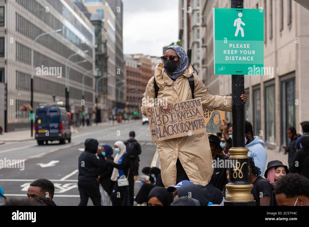 Un protester si trova accanto alla segnaletica di allontanamento sociale, Black Lives Matter dimostration, Londra, 27 giugno 2020 Foto Stock
