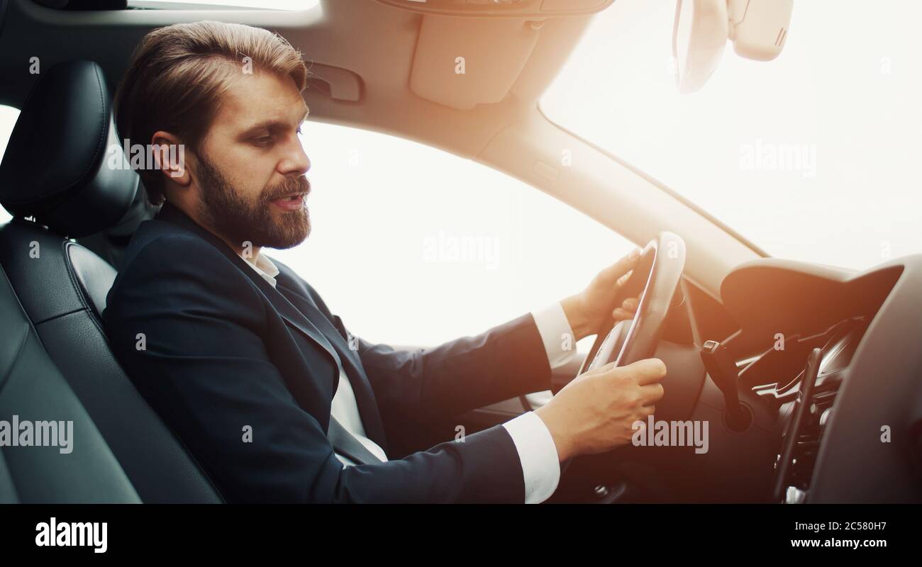 Uomo d'affari che dà comando vocale, auto Foto Stock