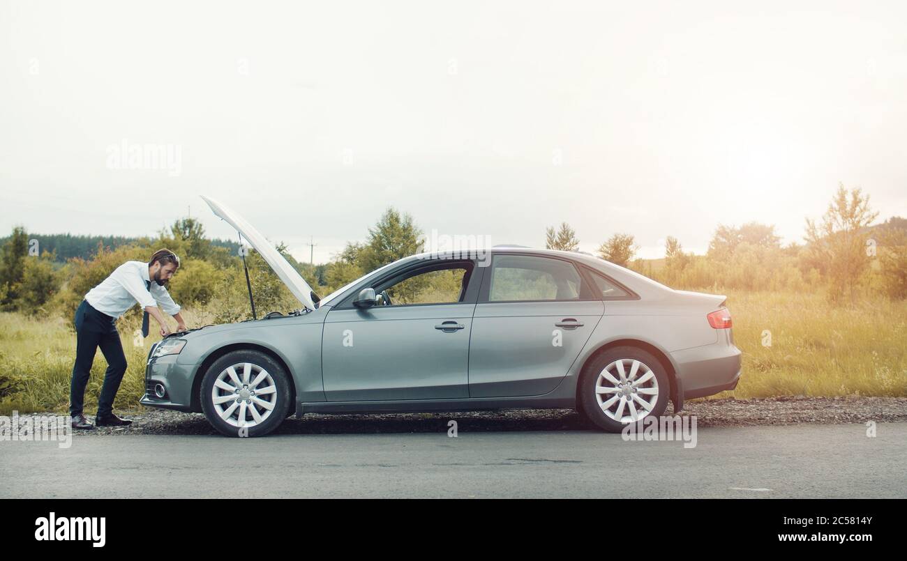 Uomo d'affari che esamina l'auto rotta Foto Stock