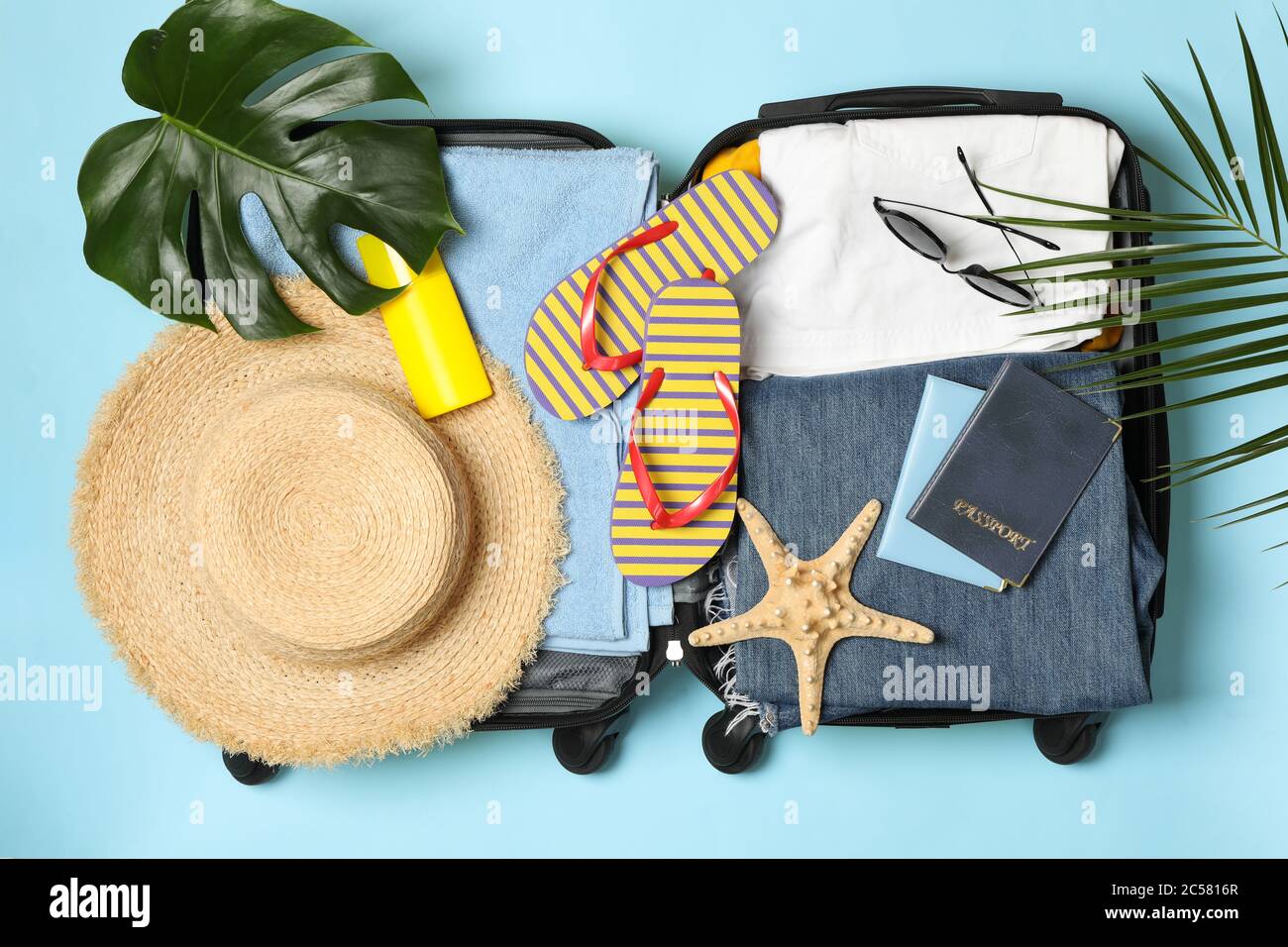 Accessori da viaggio su sfondo blu, vista dall'alto Foto Stock