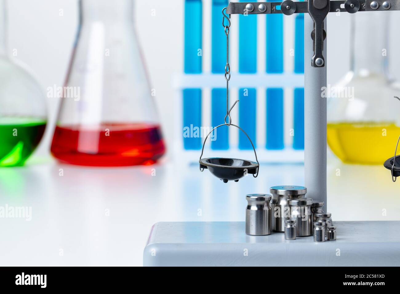 Bilance da laboratorio con pesi contro provette Foto Stock