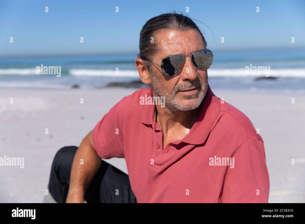 Uomo caucasico anziano che si gode del tempo in spiaggia Foto Stock