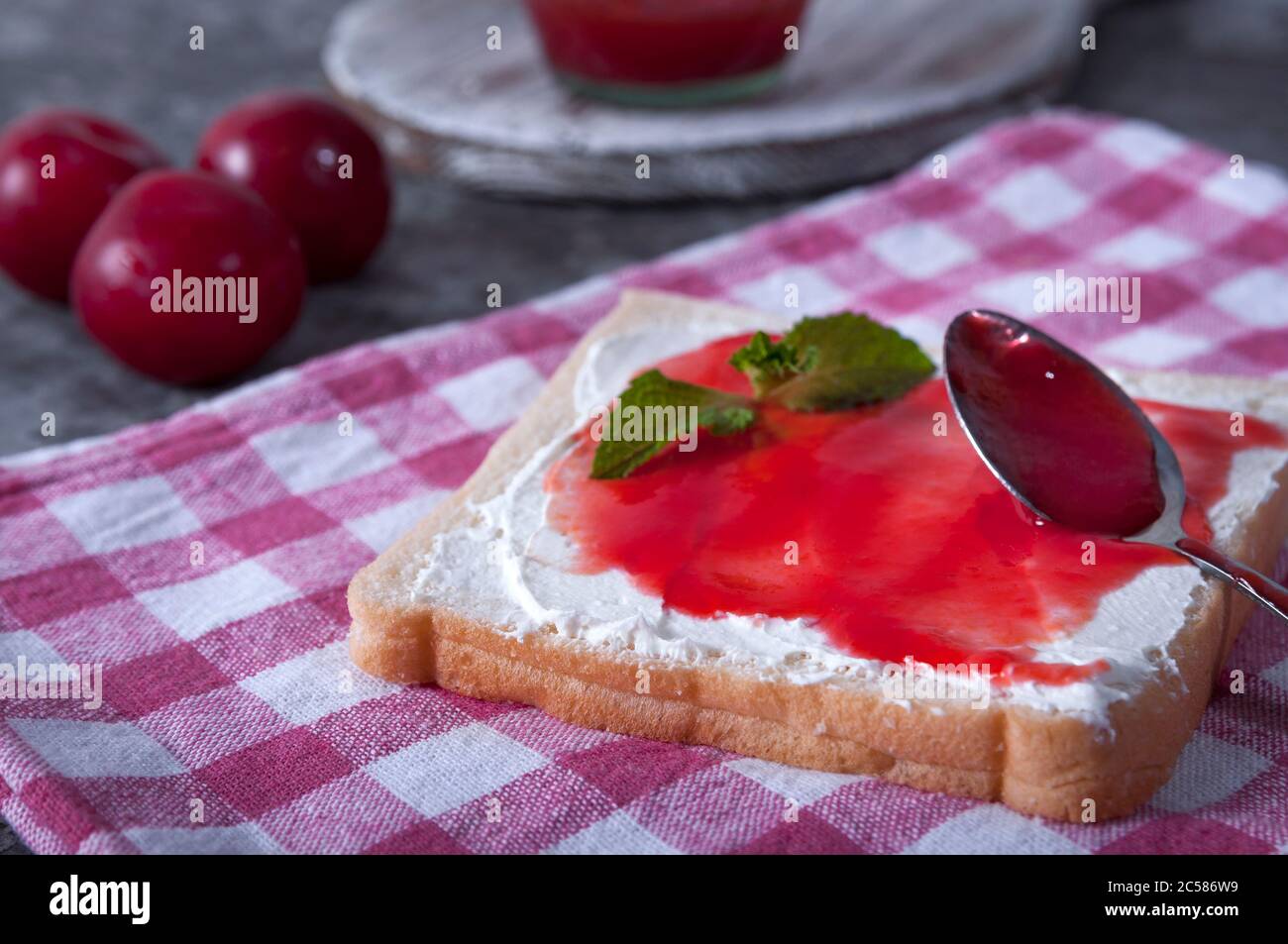 Prima colazione da un panino con formaggio e marmellata di prugne. Marmellata di prugne per colazione. Colazione gustosa. Foto Stock