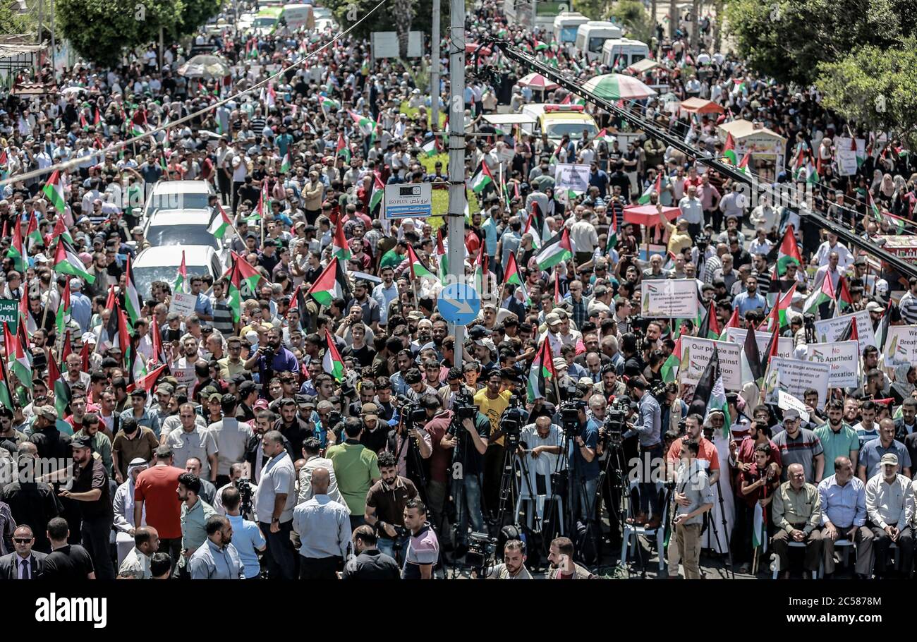 Gaza, territori palestinesi. 01 Luglio 2020. I palestinesi fanno onda di bandiere nazionali mentre prendono parte alla manifestazione "il giorno di Rage" per protestare contro il piano di annessione israeliano che occuperà circa il 30% dell'area della Cisgiordania. Il piano di annessione darebbe a Israele il controllo sui controversi insediamenti ebraici in Cisgiordania e sulla strategica Valle del Giordano. Credit: Amy/dpa/Alamy Live News Credit: amy Live News Foto Stock