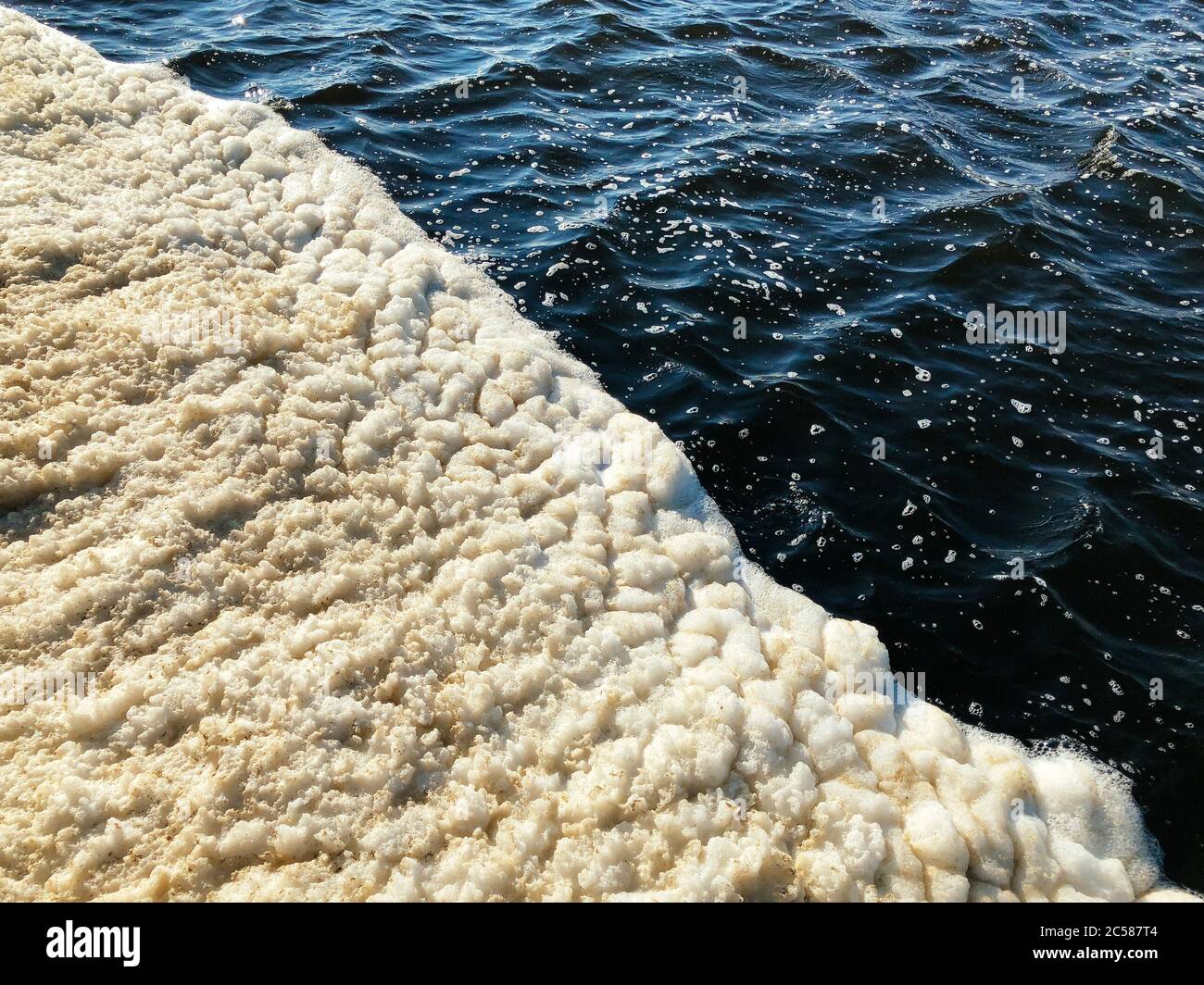 Schiuma sporca sull'acqua del lago, vista dall'alto. Foto Stock