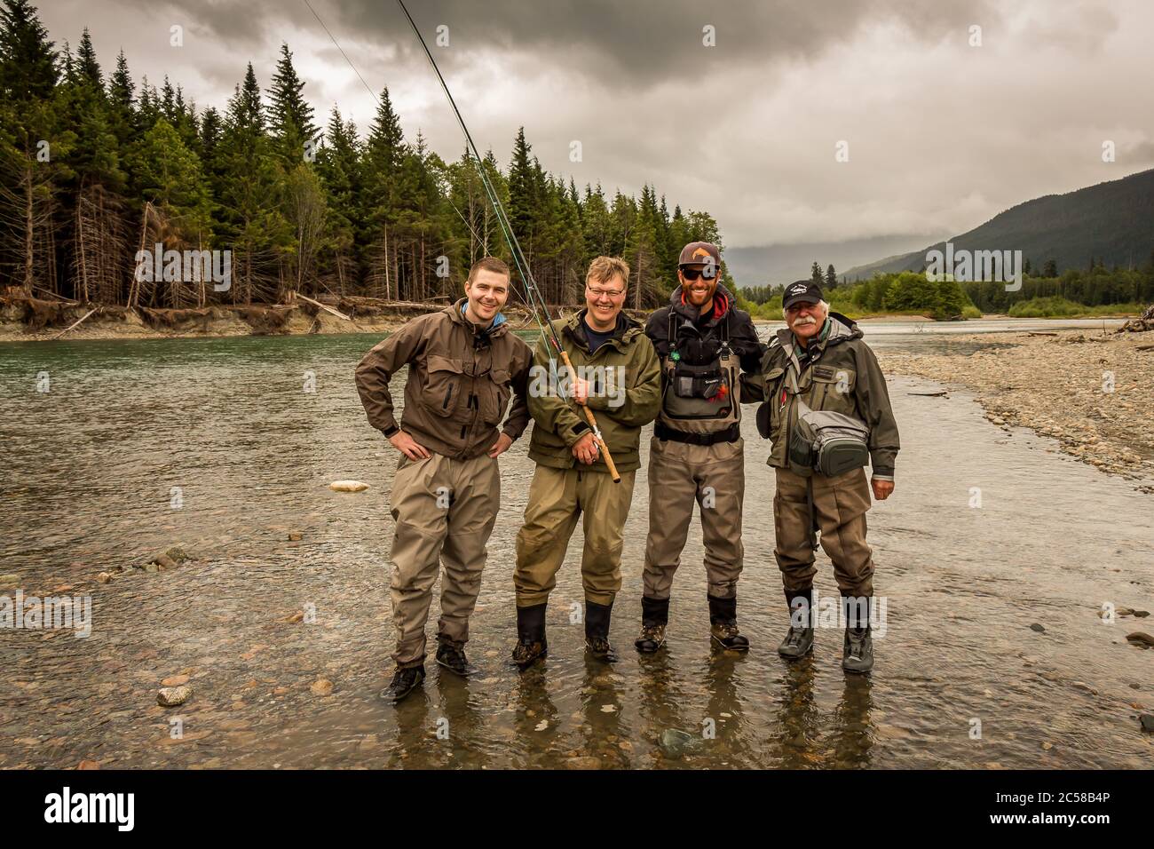 Un felice gruppo di sport volare amici pescatori su una bella scena di fiume in British Columbia, Canada Foto Stock
