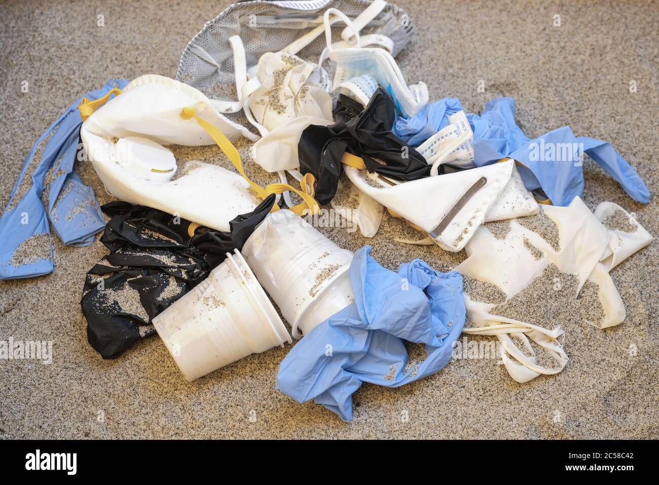 Maschera e guanti di plastica, rifiuti medici monouso sulla costa del mare, inquinamento covide, ecosistema sporco Foto Stock