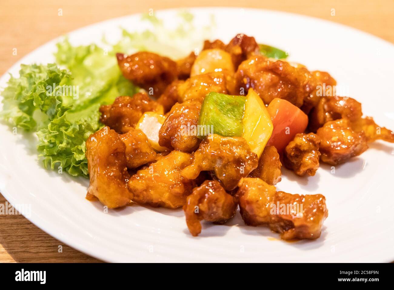 Il maiale dolce e asino con ananas, pomodoro, capsicum è un piatto cinese popolare a livello mondiale Foto Stock