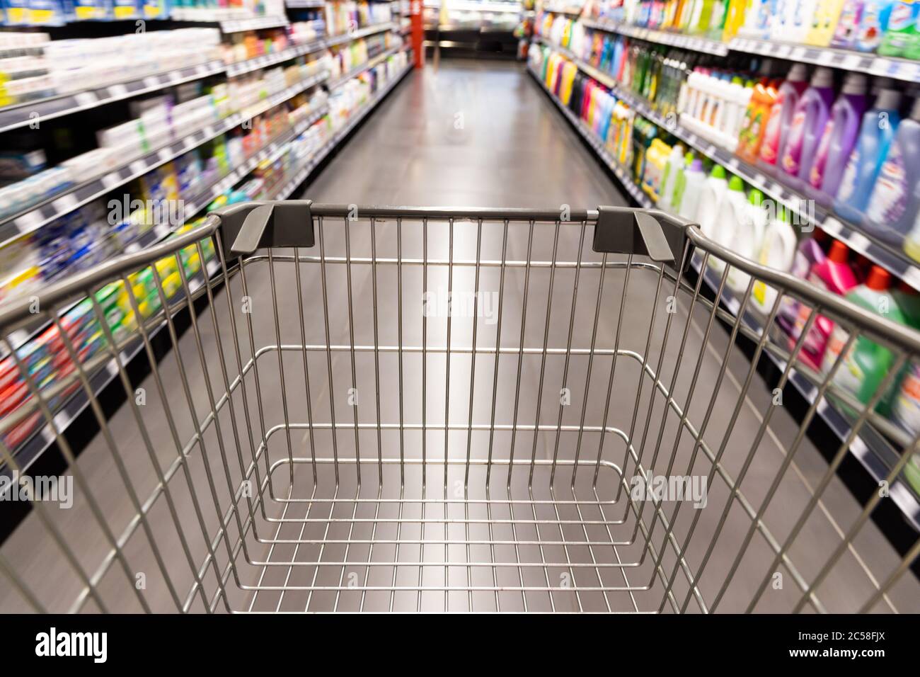 Carrello carrello di shopping che si muove in supermercato con movimento blur corsia con sfondo drogheria Foto Stock