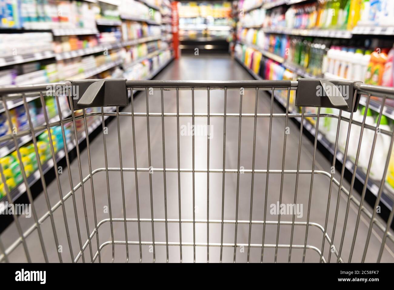 Carrello carrello di shopping che si muove in supermercato con movimento blur corsia con sfondo drogheria Foto Stock