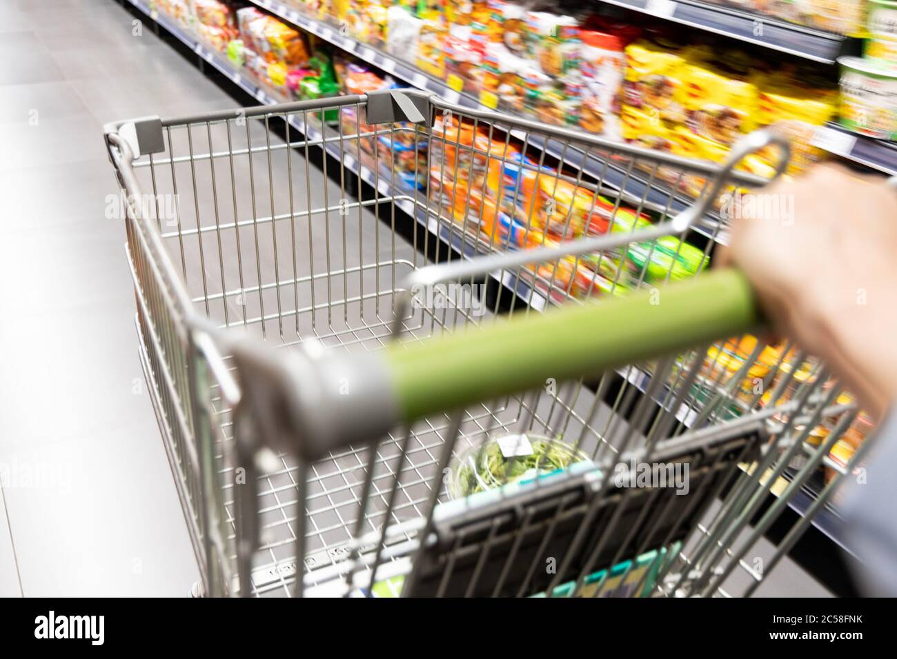 Carrello carrello di shopping che si muove in supermercato con movimento blur corsia con sfondo drogheria Foto Stock