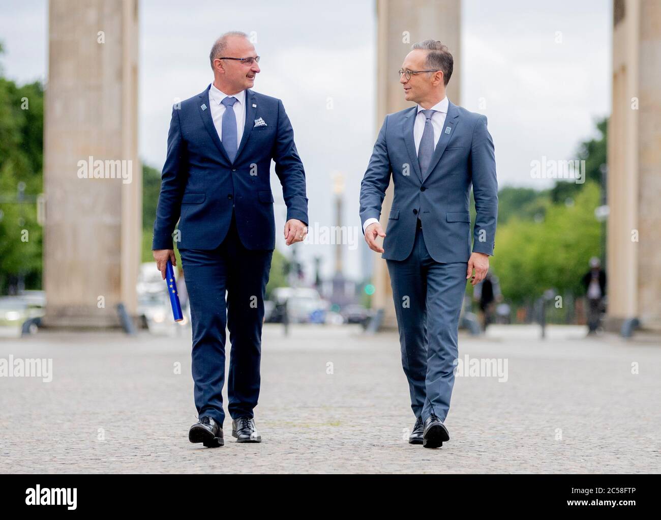 Berlino, Germania. 01 Luglio 2020. Heiko Maas (SPD, r), ministro degli Affari esteri, e Gordan Grlic Radman, ministro degli Affari esteri della Repubblica di Croazia, arrivano alla porta di Brandeburgo per una sessione fotografica con un testimone simbolico in occasione della presidenza tedesca del Consiglio UE dalla Croazia. Dal 1° luglio la Germania assume la presidenza del Consiglio dell'UE sotto il motto "insieme". Rendere l'Europa ancora forte». Il logo presenta una striscia di Möbius, simbolo di unità e solidarietà. Credit: Christoph Soeder/dpa/Alamy Live News Foto Stock