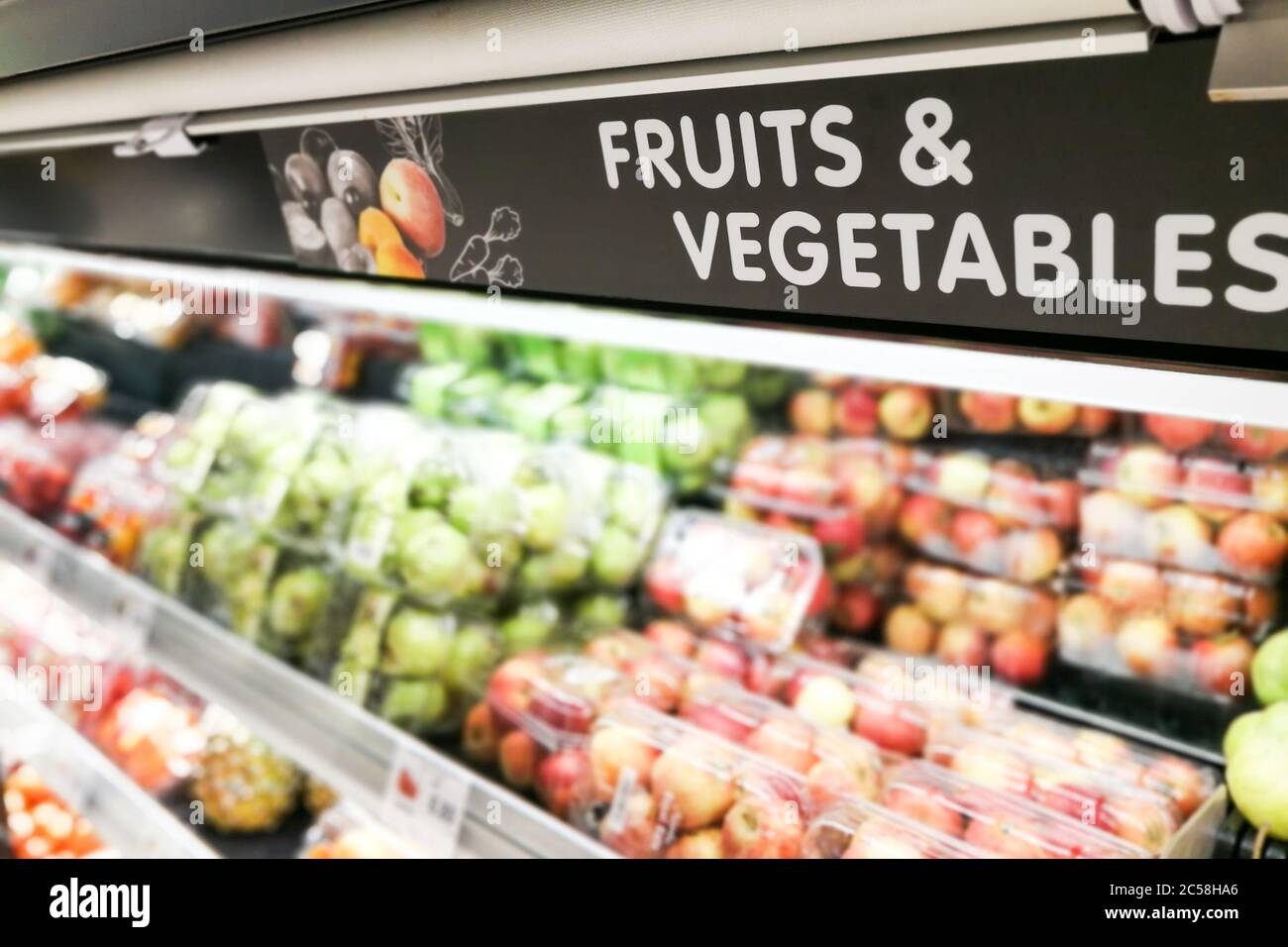 La segnaletica per frutta e verdura al supermercato ha prodotto una sezione di cibo con sfondo sfocato Foto Stock