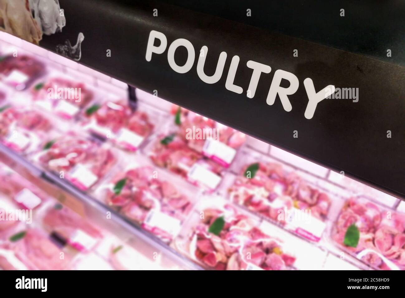 Segnaletica di pollame presso la sezione di prodotti deperibili di carne del supermercato con sfondo sfocato Foto Stock