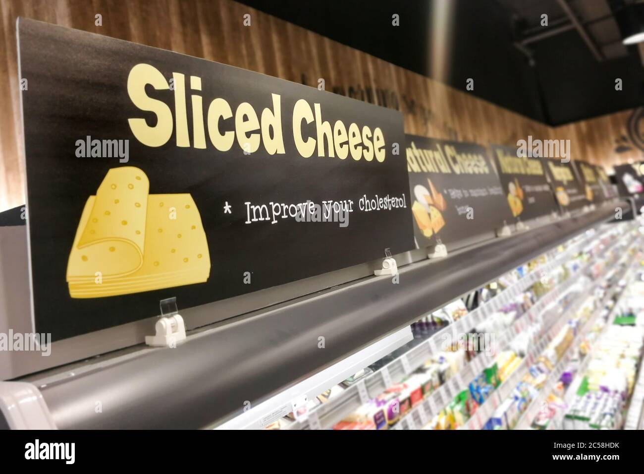 La segnaletica del formaggio presso il supermercato refrigerato produce una sezione di cibo con sfondo sfocato Foto Stock