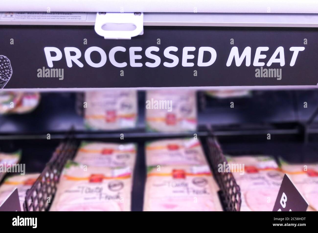 Segnaletica di carne lavorata nella sezione di carne del supermercato con sfondo sfocato Foto Stock