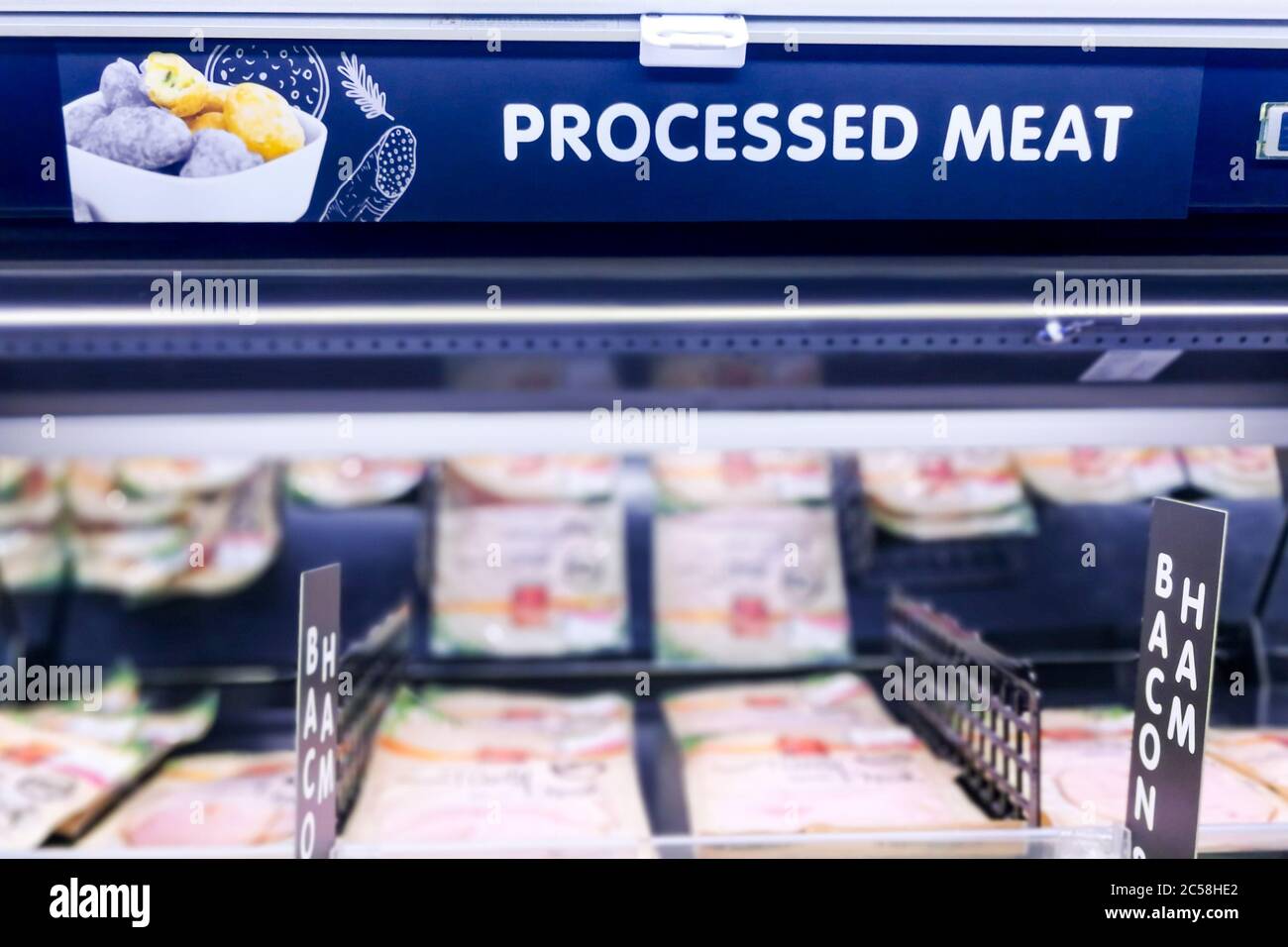 Segnaletica di carne lavorata nella sezione di carne del supermercato con sfondo sfocato Foto Stock