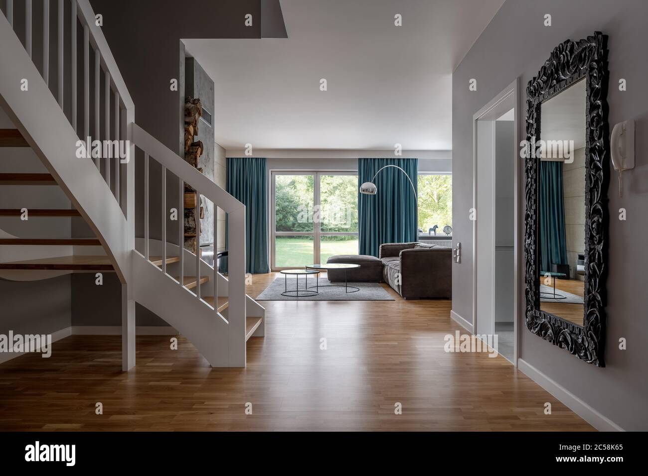 Interni accoglienti con scale in legno e soggiorno aperto Foto Stock