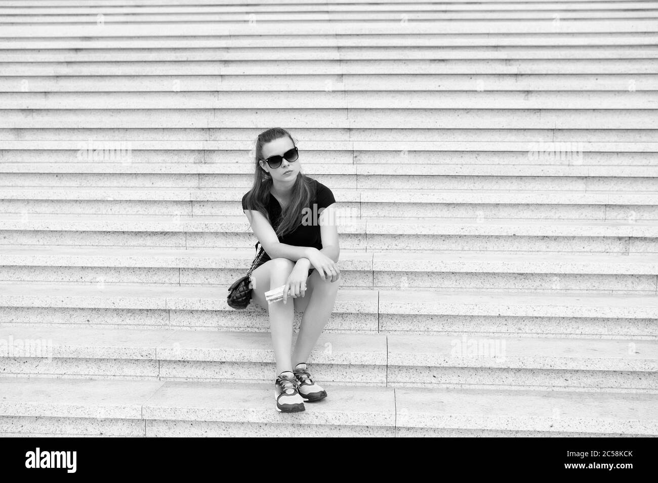 Escursione turistica con guida turistica. Idee vacanza. Vacanza in grande città. Donna rilassante. Orari di apertura del museo. Ragazza turistica sedersi e aspettare le scale. Pronto a esplorare la città. Concetto di vacanza e di viaggio. Foto Stock