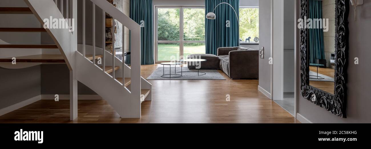 Interni moderni con scale in legno e soggiorno aperto, panorama Foto Stock