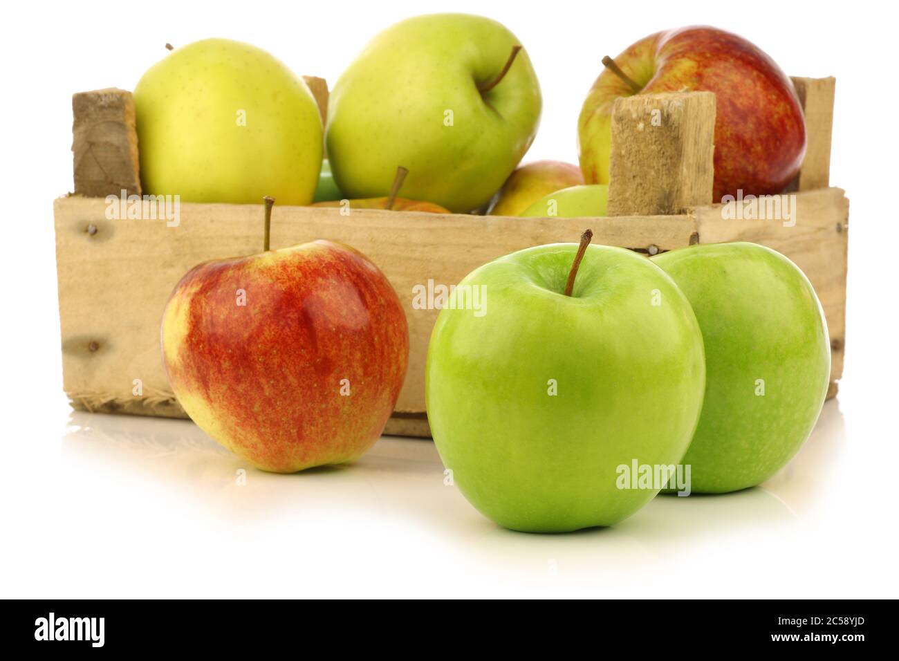 mele fresche assortite in una cassa di legno su sfondo bianco Foto Stock