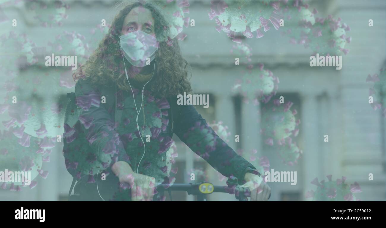 Covid-19 cellule contro donna che indossa maschera facciale bicicletta da corsa Foto Stock