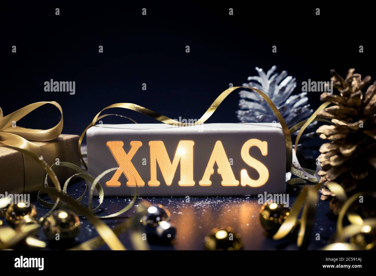 Buon natale, Natale e celebrazione concetti con xmas lightbox testo e ornamento in colore dorato su sfondo scuro.stagione invernale e anniversario da Foto Stock