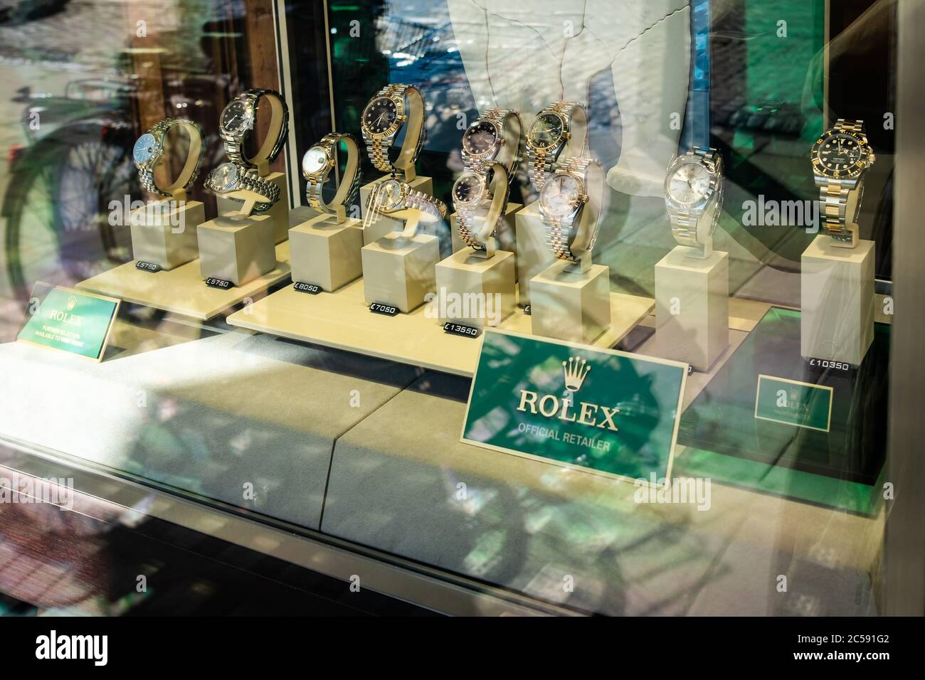 Vetrina di shopping vista di un noto, orologio di lusso marchio logo visto in una vetrina gioielleria. Foto Stock